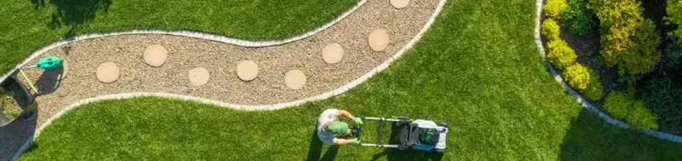 Aerial drone view of a finished residential landscaping project in Edmonton featuring fresh sod, a curved rock pathway, and stepping stones.